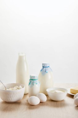 Lezzetli organik süt ürünleri ve yumurtalar ahşap masa üzerinde izole edilmiş beyaz