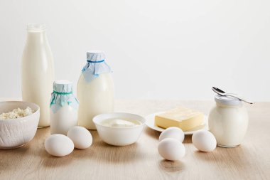Lezzetli organik süt ürünleri ve yumurtalar ahşap masa üzerinde izole edilmiş beyaz