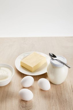 Lezzetli organik süt ürünleri ve yumurtalar ahşap masa üzerinde izole edilmiş beyaz