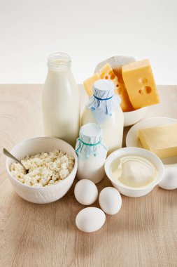 Lezzetli organik süt ürünleri ve yumurtalar ahşap masa üzerinde izole edilmiş beyaz