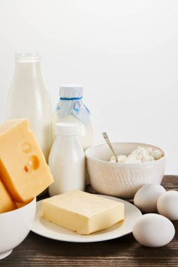 Lezzetli taze süt ürünleri ve yumurtalar ahşap masa üzerinde izole edilmiş beyaz