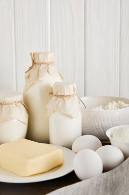 Lezzetli taze süt ürünleri ve beyaz ahşap arka planda yumurtalar