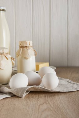 Lezzetli taze süt ürünleri ve beyaz ahşap arka planda yumurtalar