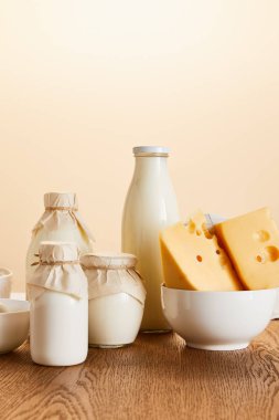 Lezzetli organik süt ürünleri ve kırsal ahşap masa üzerindeki yumurtalar bej renginde izole edilmiş.