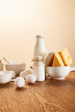 tasty organic dairy products and eggs on rustic wooden table isolated on beige clipart