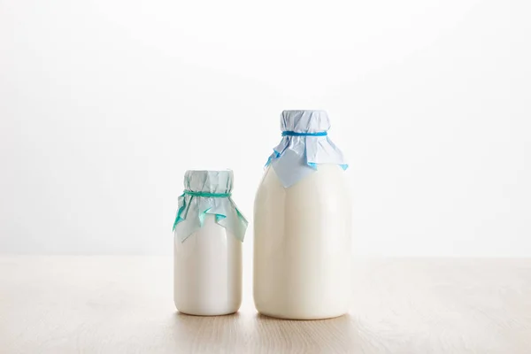 白に隔離された木製のテーブルの上に瓶の中の様々な新鮮な有機乳製品 — ストック写真