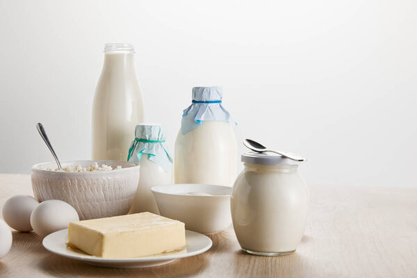 fresh organic dairy products and eggs on wooden table isolated on white