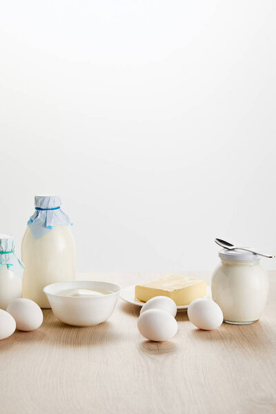 delicious organic dairy products and eggs on wooden table isolated on white