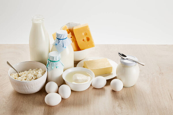 вкусные органические молочные продукты и яйца на деревянном столе, изолированные на белом
