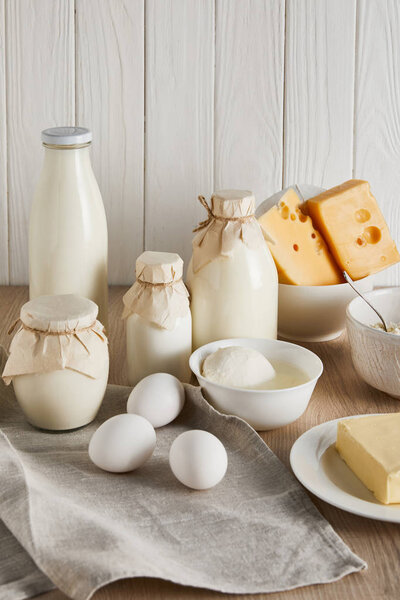 вкусные свежие молочные продукты и яйца на белом деревянном фоне
