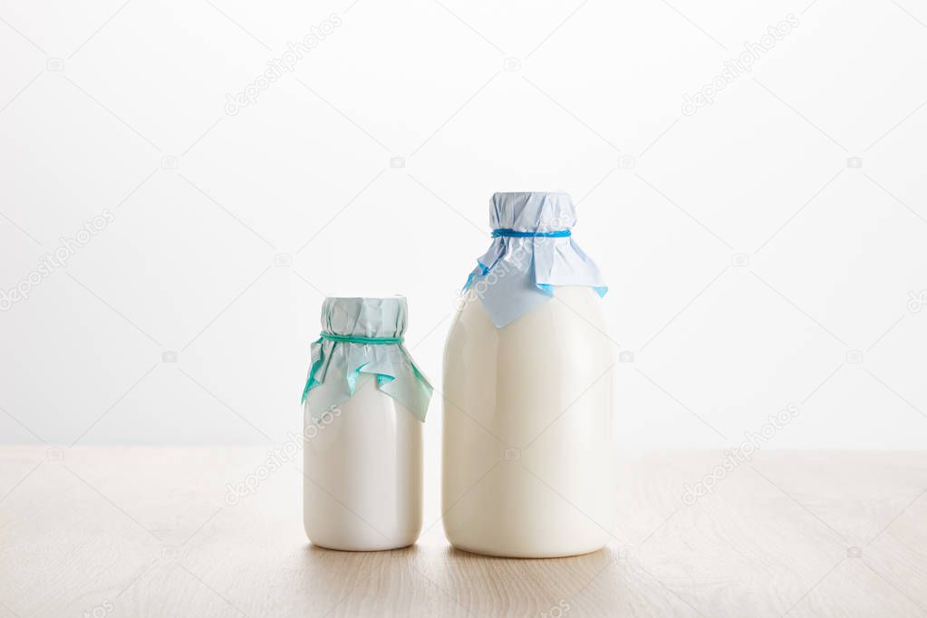 various fresh organic dairy products in bottles on wooden table isolated on white