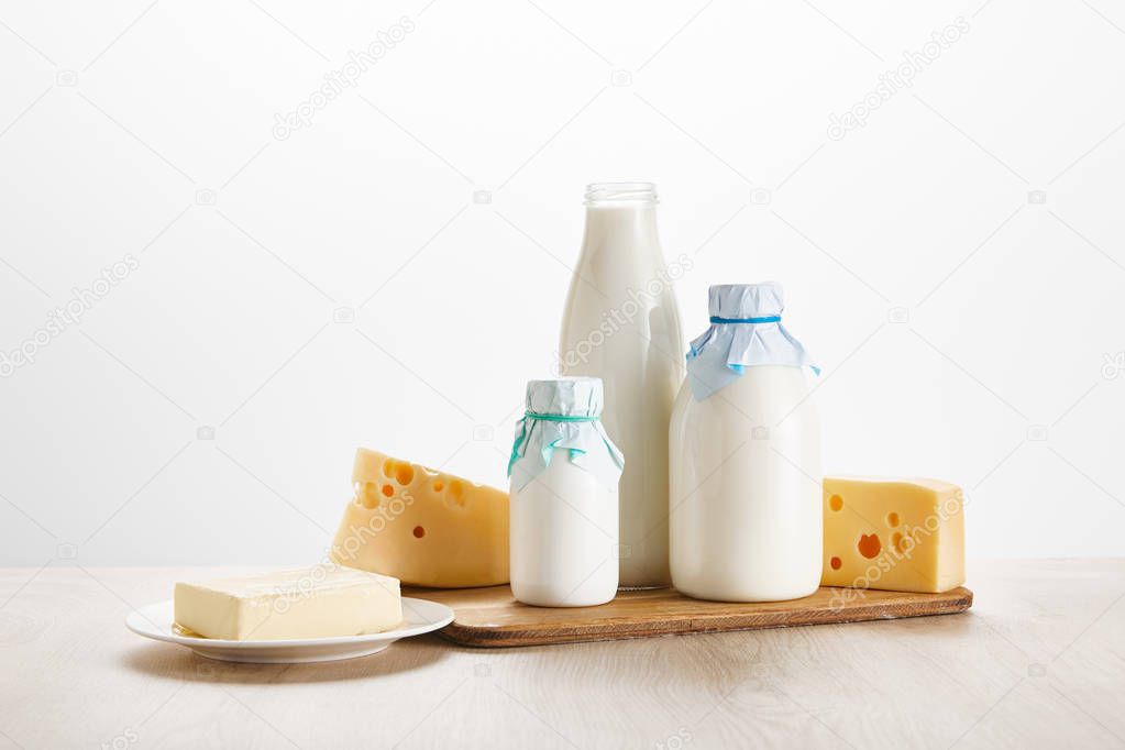 various fresh organic dairy products on wooden board isolated on white