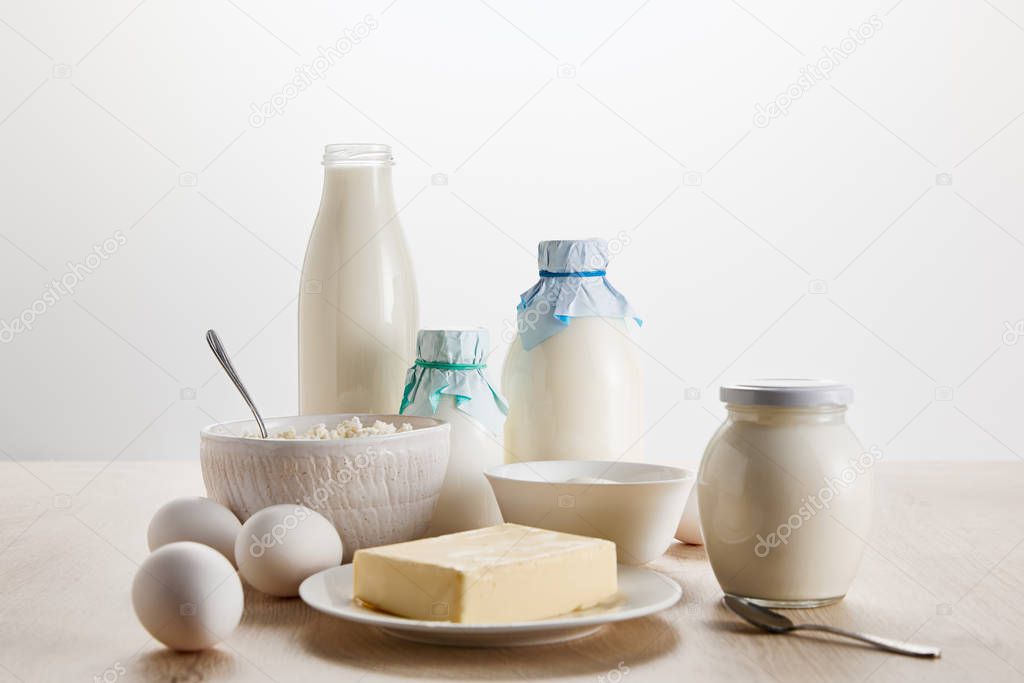 various fresh organic dairy products and eggs on wooden table isolated on white