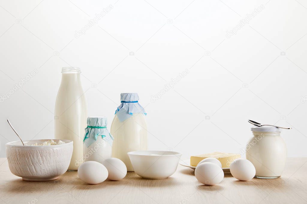 fresh organic dairy products and eggs on wooden table isolated on white