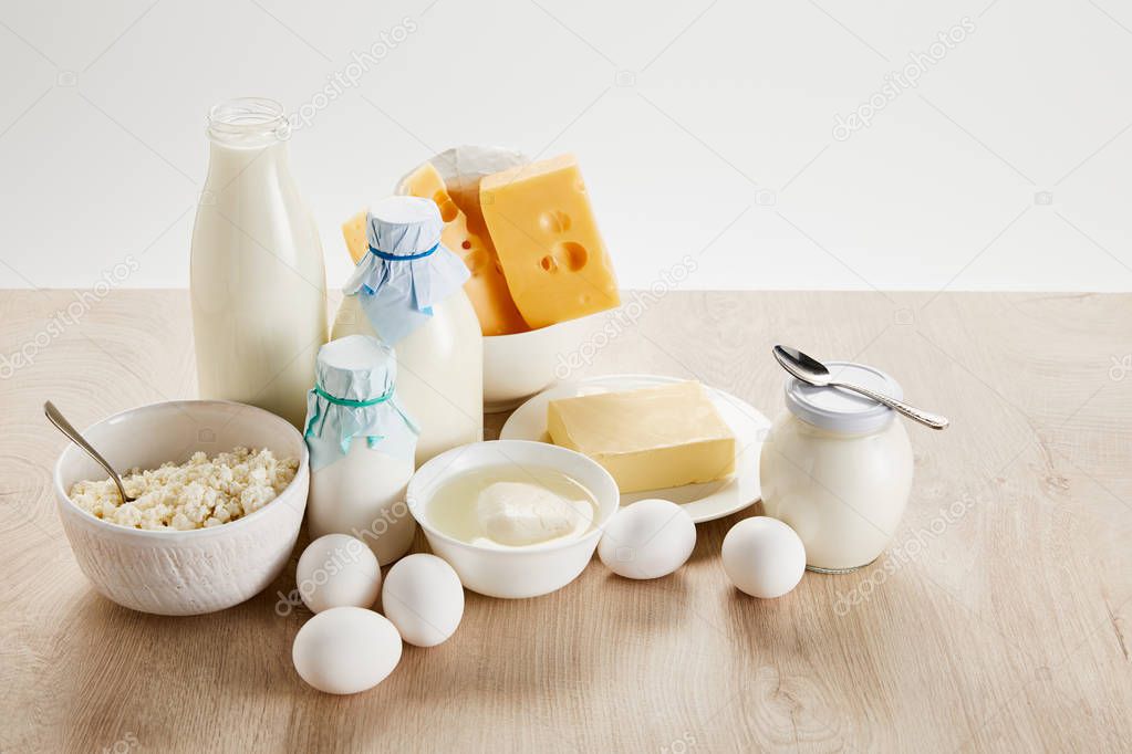 delicious organic dairy products and eggs on wooden table isolated on white