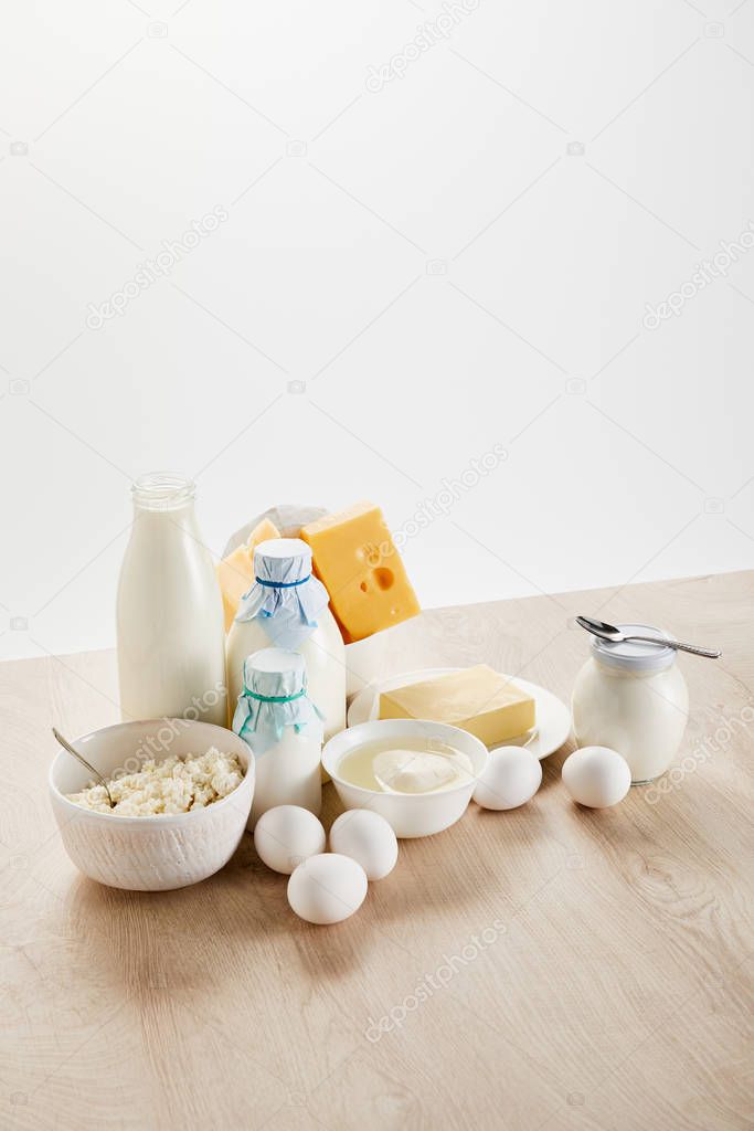 delicious organic dairy products and eggs on wooden table isolated on white