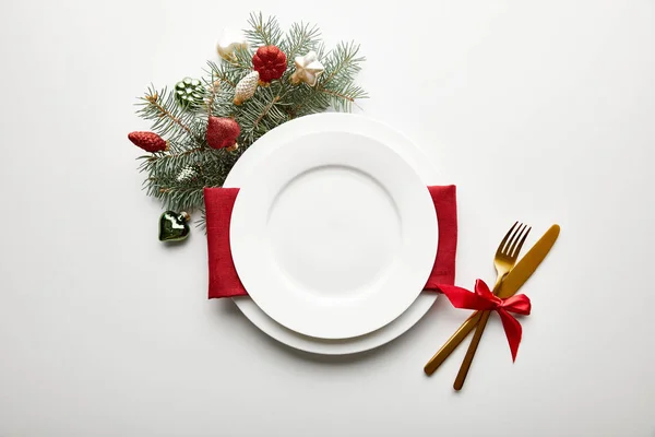 装飾された松の枝と白い背景にお祝いのクリスマステーブルの設定のトップビュー — ストック写真