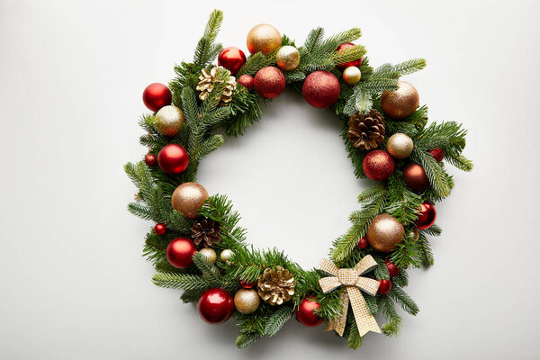 top view of festive Christmas wreath with baubles on white background