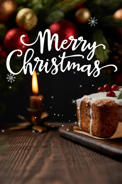 传统圣诞蛋糕的精选焦点 在圣诞花圈附近放上覆盆子 在木制桌子上放上蜡烛 并附有圣诞快乐的图解 — 图库照片