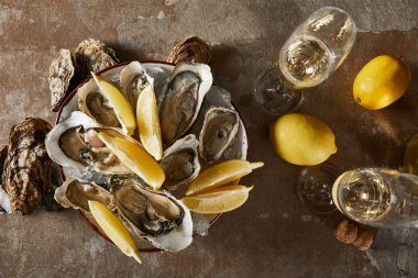 Lezzetli istiridye ve limonlar şampanya bardaklarının yanında köpüklü şarapla birlikte. 