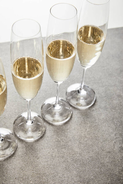 champagne glasses with sparkling wine on grey surface