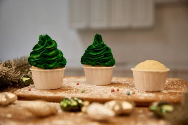 Lezzetli keklerin seçici odak noktası Noel baloları ve masada ladin dalı.
