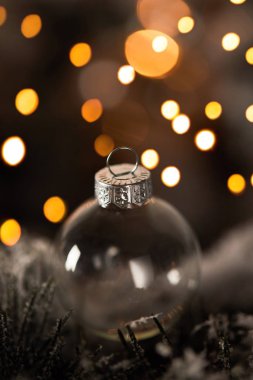 Sarı ışıklarla kaplı ladin dallarında şeffaf noel balosunu kapatın.