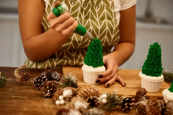 Cropped View Confectioner Adding Green Sweet Cream Christmas Tree Cupcakes — ストック写真
