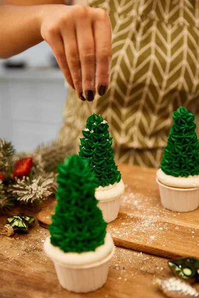 Abgeschnittene Ansicht Des Konditors Der Dekor Auf Weihnachtsbaum Cupcakes Neben — Stockfoto