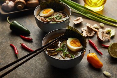 Kavanozlu ve taş yüzeyinde sebzeli geleneksel baharatlı ramen.