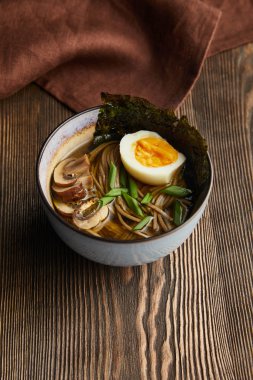 Ahşap masada peçeteli geleneksel baharatlı ramen.