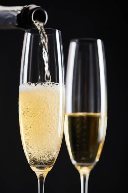 close up of champagne pouring into glasses for celebrating christmas, isolated on black  clipart