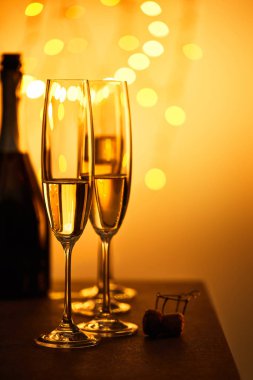 Mantar, şişe ve bardaklar köpüklü şarap, sarı noel ışıkları bokeh