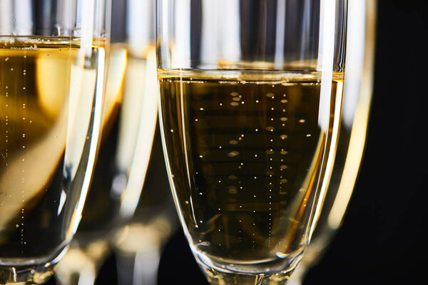 close up of sparkling wine in glasses for celebrating christmas, isolated on black 