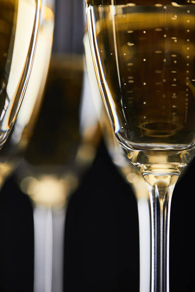 close up of glasses with champagne for celebrating christmas, isolated on black 