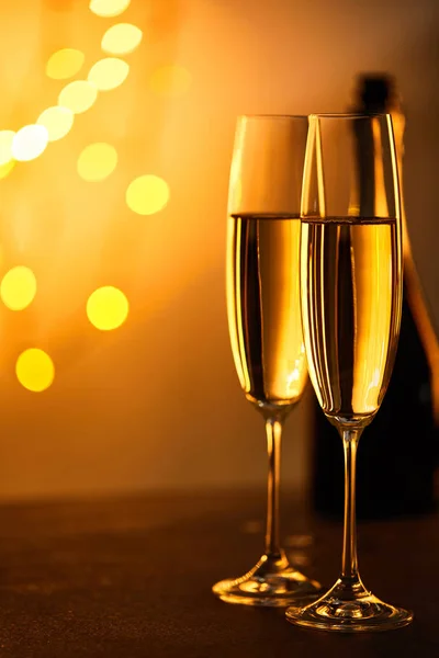 Bicchieri Champagne Con Bottiglia Sfocata Luci Natale Gialle — Foto Stock