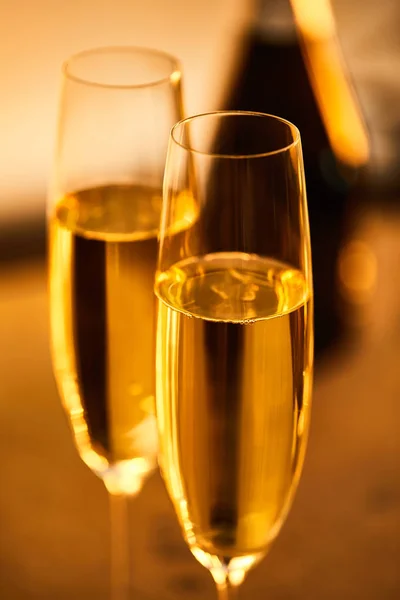 Glas Champagne Med Suddig Flaska Och Gula Julbelysning — Stockfoto
