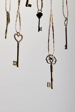 vintage keys hanging on ropes isolated on white clipart