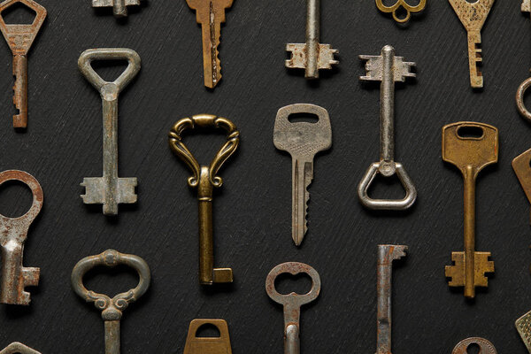 top view of vintage rusty keys on black background