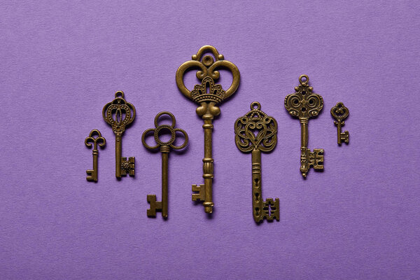 top view of vintage keys on violet background