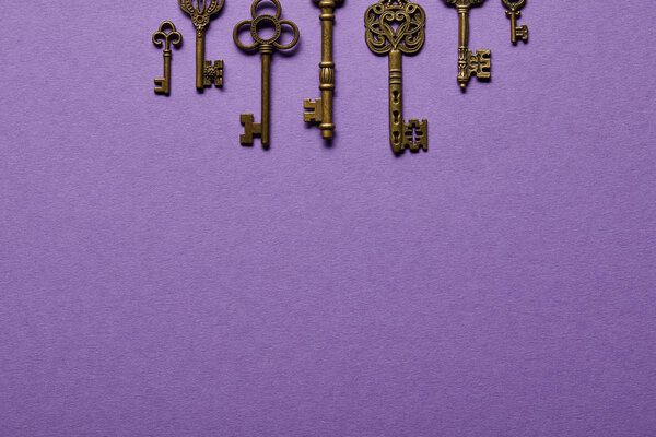 top view of vintage keys on violet background with copy space