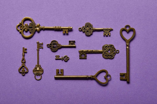 top view of vintage keys on violet background