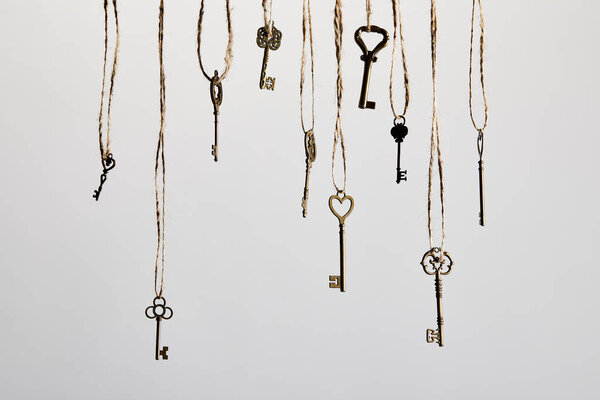 vintage keys hanging on ropes isolated on white