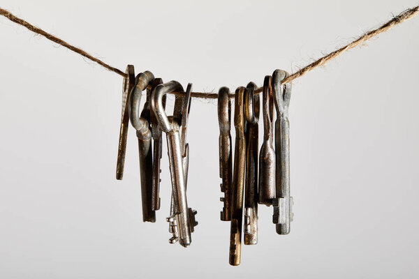 винтажные ржавые ключи висят на веревке изолированы на белом
