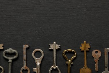 flat lay with vintage rusty keys on black background clipart