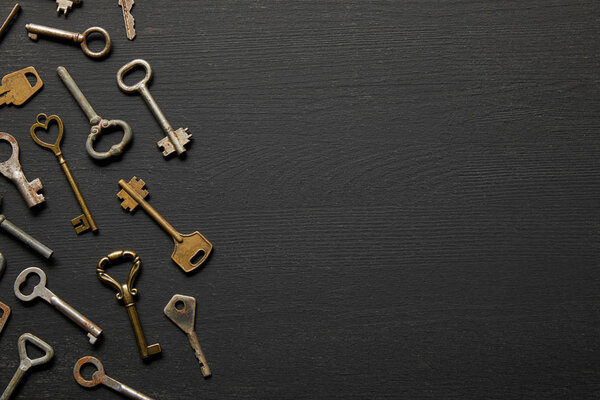 top view of vintage rusty keys on black background