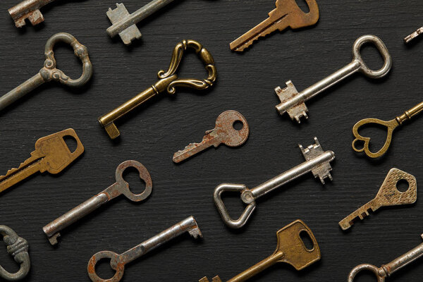 seamless pattern with vintage rusty keys on black background
