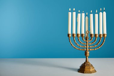 burning candles in menorah isolated on blue clipart