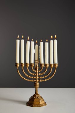 burning candles in menorah isolated on grey clipart