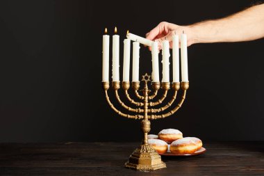 Menorah 'ta mumları yakan adamın görüntüsü siyah çöreğin yanında.